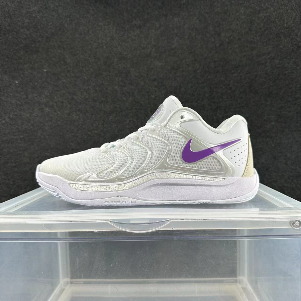 White Nike sneakers with a purple Swoosh and layered side panels