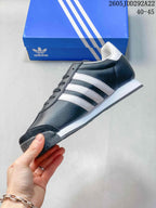 Side view of a dark gray adidas Samoa sneaker with white three-stripe details and a low white midsole.