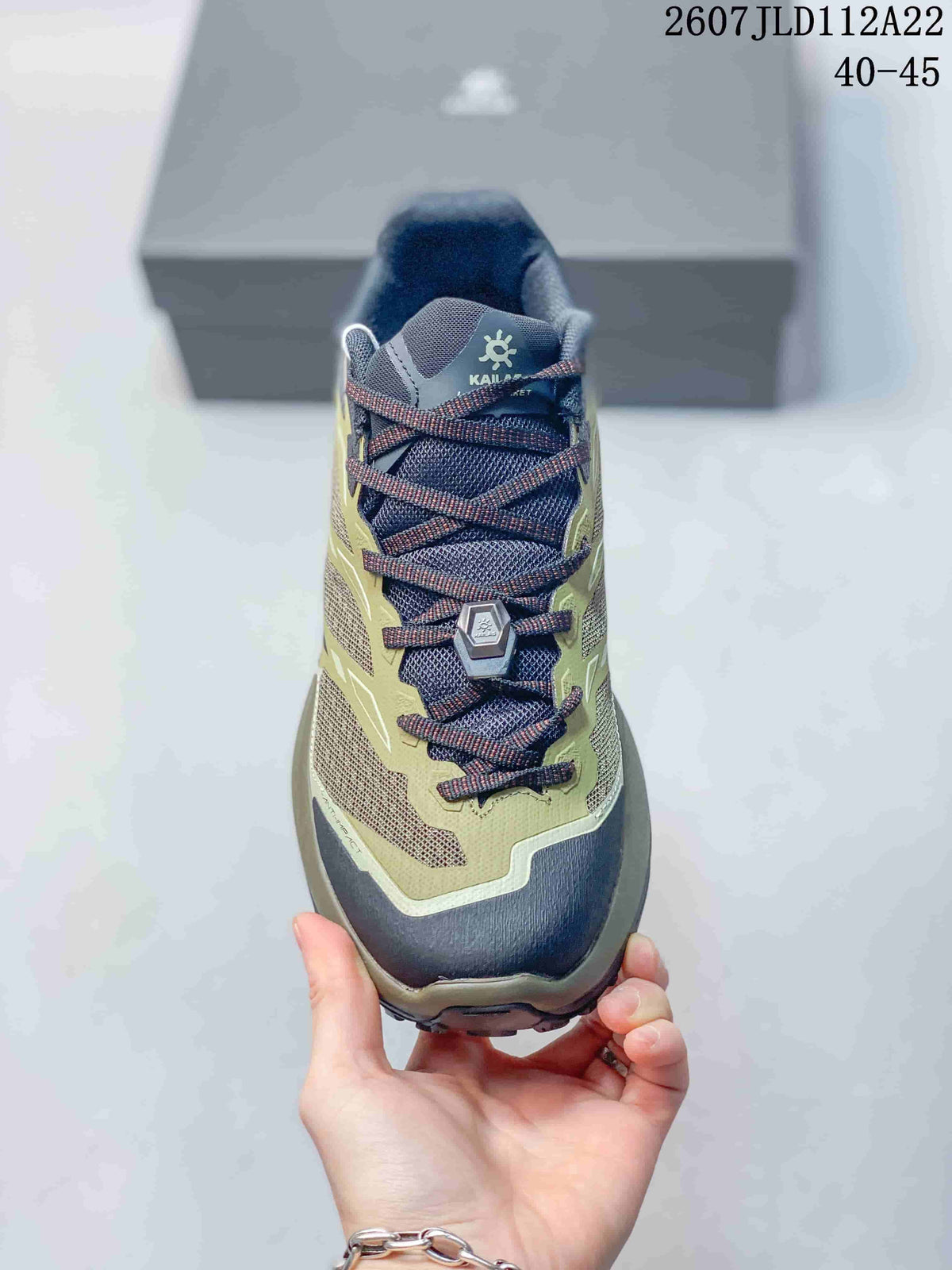 Top view showing the mesh tongue, lace system, metal-look lace hardware, and olive-and-navy color blocking.