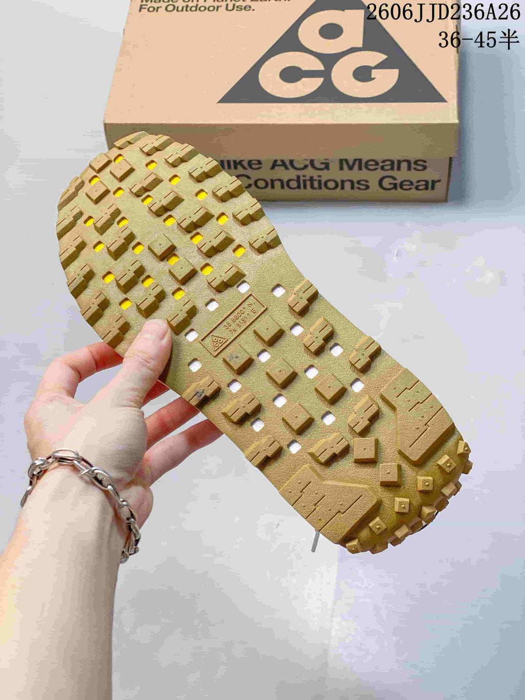 Close view of the sneaker's gum-colored outsole showing a raised lug tread pattern and drainage-style openings.