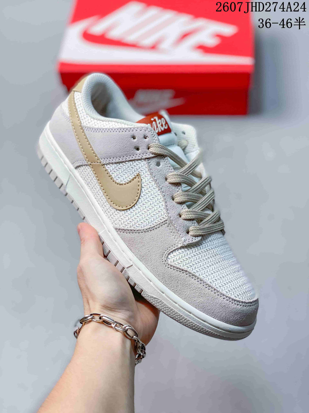 Angled side view showing the white and light gold colorway, lace-up construction, and low-top silhouette.