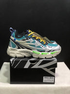 Side view of a teal mesh sneaker with layered white and black overlays, yellow laces, and a chunky off-white sole.