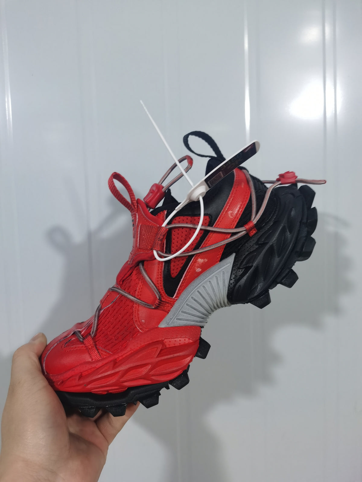 Red and black Balenciaga Hike sneaker shown from the side, highlighting the layered upper, gray side panel, looped laces and rugged outsole.