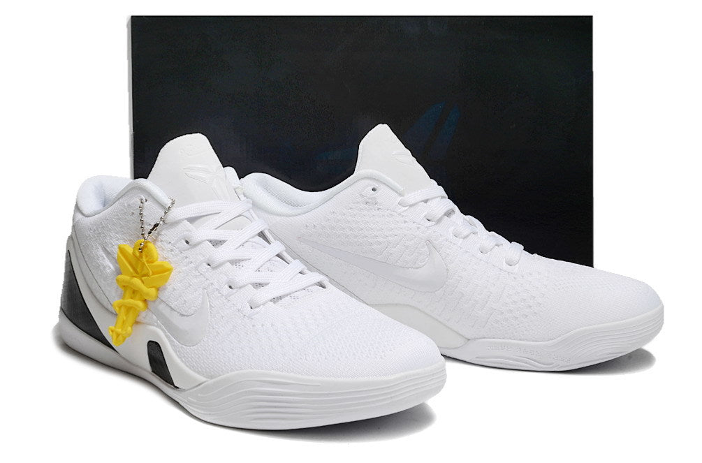 Pair of all-white shoes with a dark box behind them.