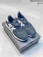Pair of navy Armani Exchange AX low-top sneakers with white side detailing and white outsoles on a branded box.
