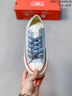 Top-down view of the light blue sneaker showing blue laces, silver-tone eyelets, white toe cap, and tongue detailing.