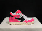 Single sneaker side profile showing the pink heel and toe accents, white upper, black arrow motif, and cream outsole.