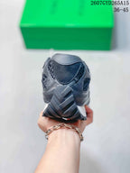 Rear view of the black sneaker showing the heel structure, layered panels, and outsole tread.