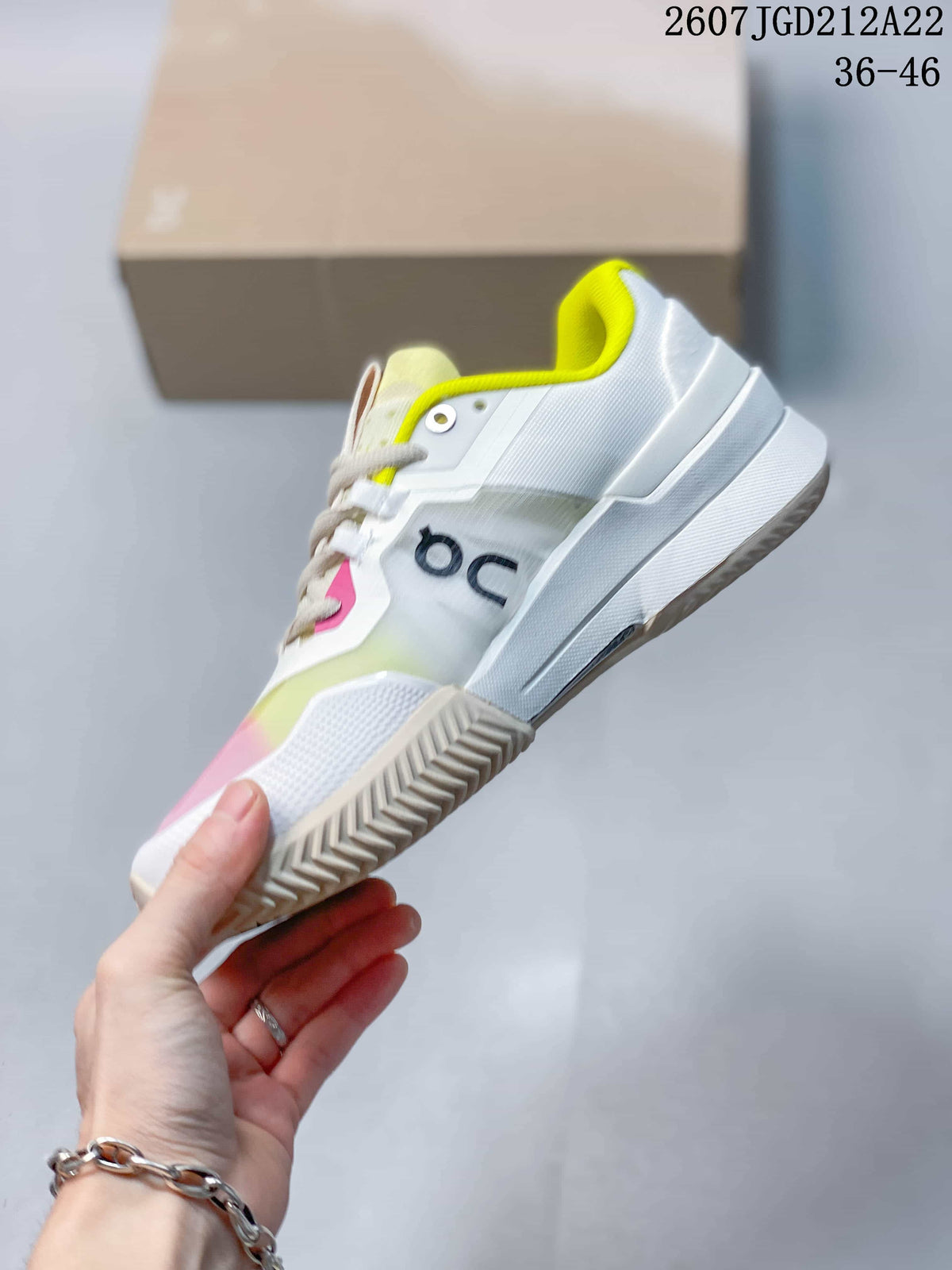 Side view of the sneaker showing the white layered upper, dark On logo and patterned outsole.