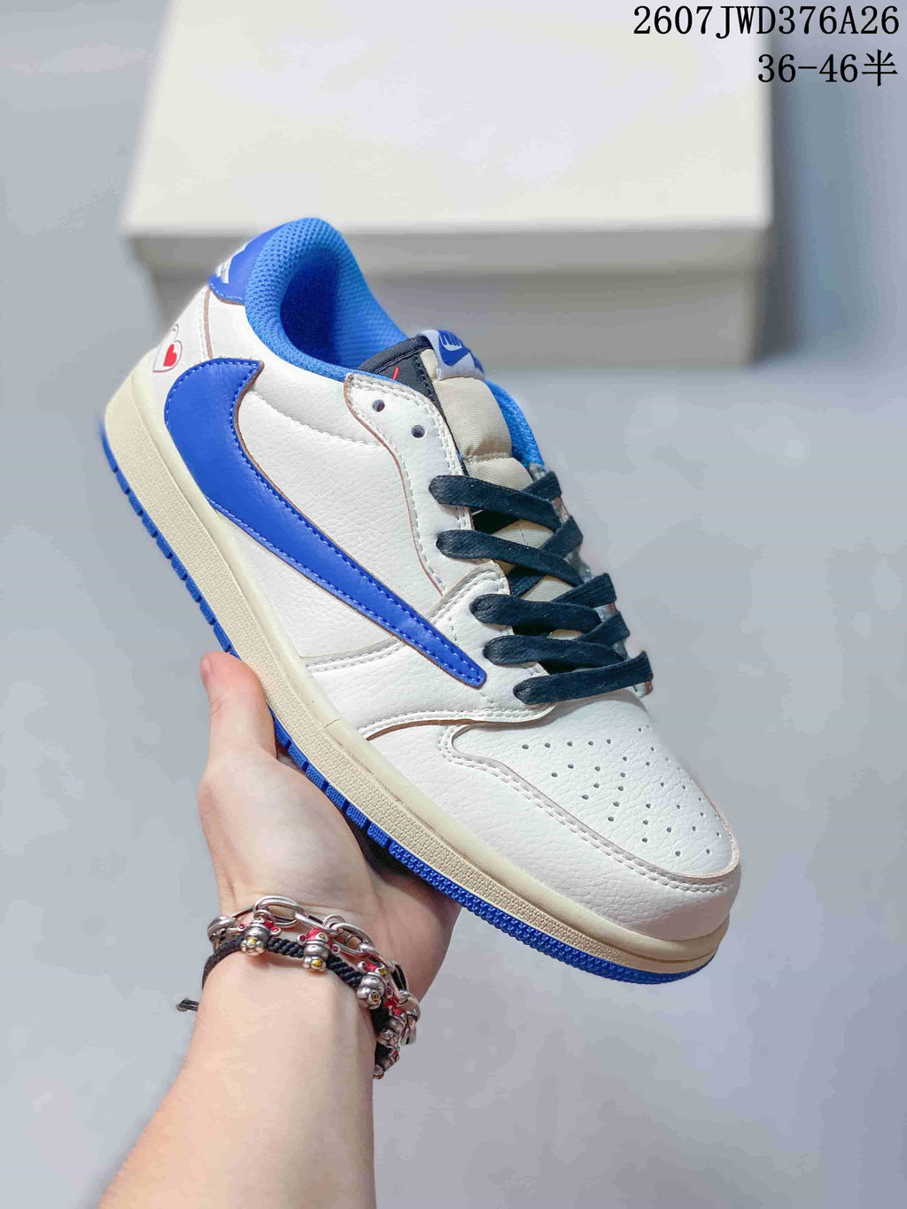 Angled side view of the white and blue low-top sneaker with a cream midsole and blue outsole.