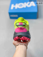 Rear view of the green running shoe showing the padded collar, pink heel accent, and outsole.