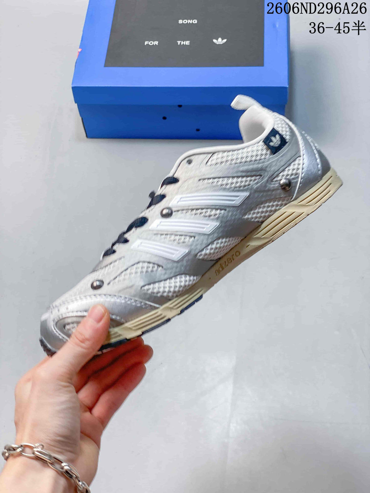 Side profile showing the layered silver and white upper, navy details and low-top shape.