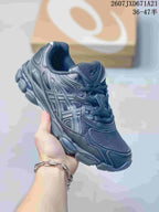 Dark gray and navy ASICS GEL-Kayano 14 sneaker shown from a front three-quarter angle.