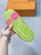 Underside of a green sneaker showing the textured rubber outsole, pink heel detail, and molded branding.
