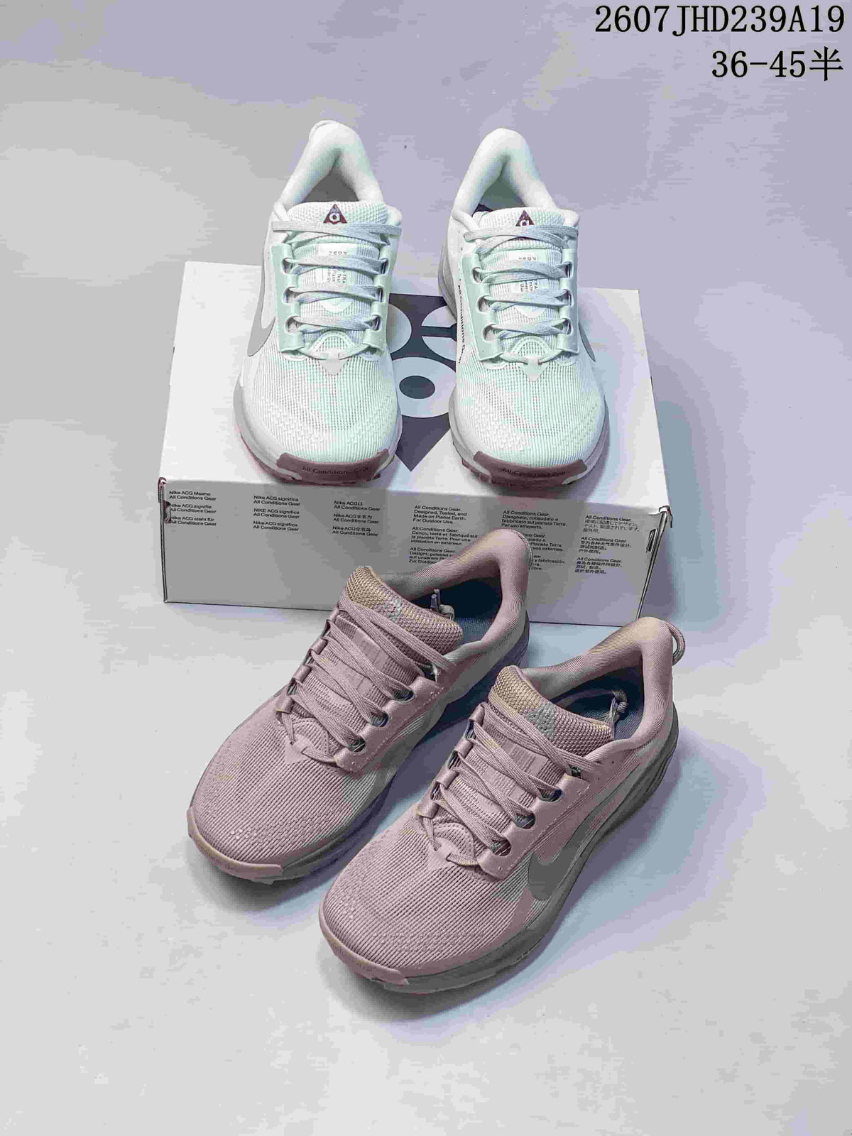 Pale mint and mauve-gray Nike ACG Pegasus Trail sneakers shown together with their shoebox.
