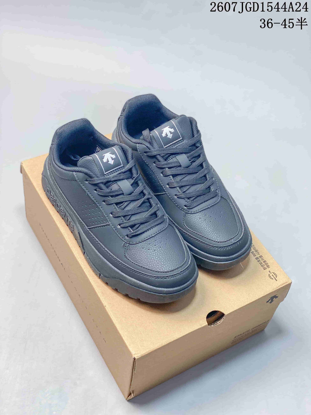 Navy DESCENTE Dualis low-top sneakers with matching laces and padded collars displayed on a shoe box.