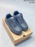 Navy DESCENTE Dualis low-top sneakers with matching laces and padded collars displayed on a shoe box.