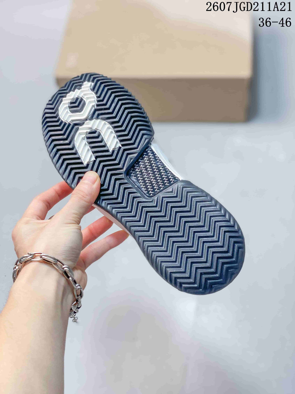 Underside of an On sneaker showing a dark patterned rubber outsole with herringbone-style tread.