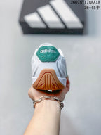 Rear view of the white adidas trainer showing the green heel tab and gum outsole