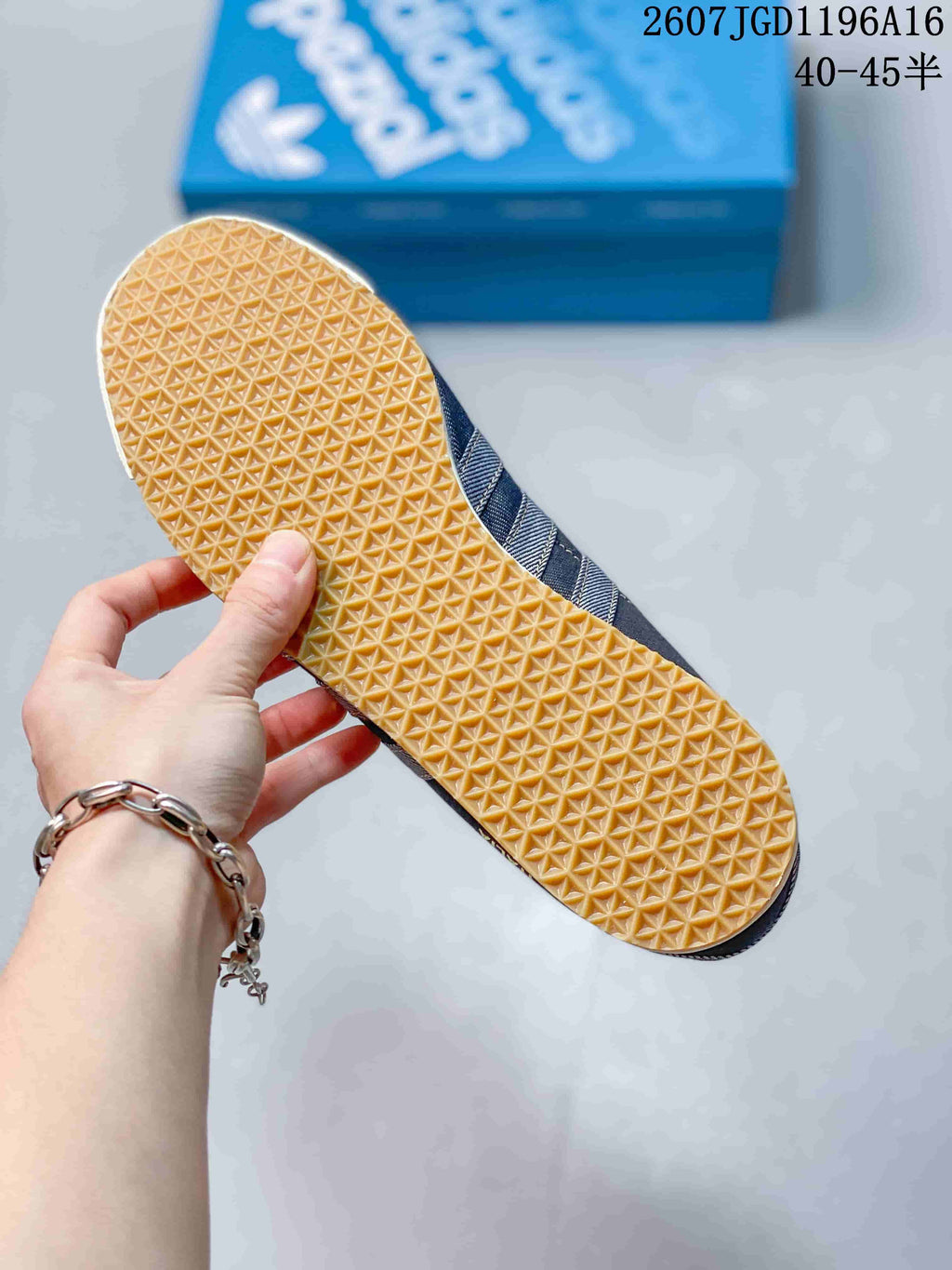 Close view of the sneaker outsole showing a repeating gum-colored textured traction pattern.