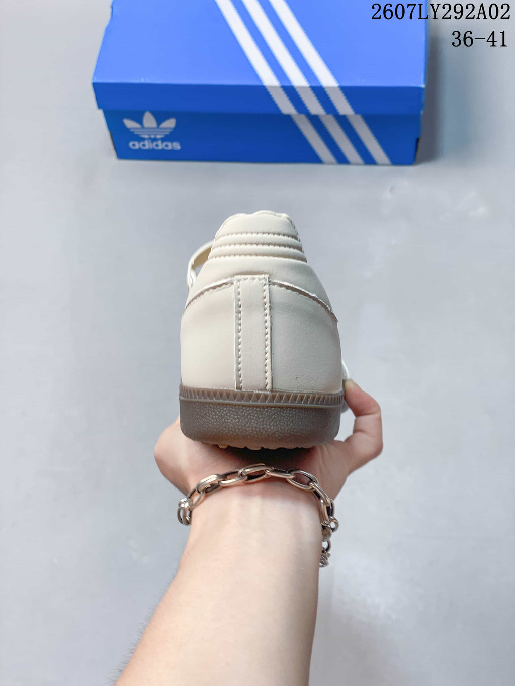 Rear view of the cream sneaker showing the heel construction and gum-colored outsole edge.
