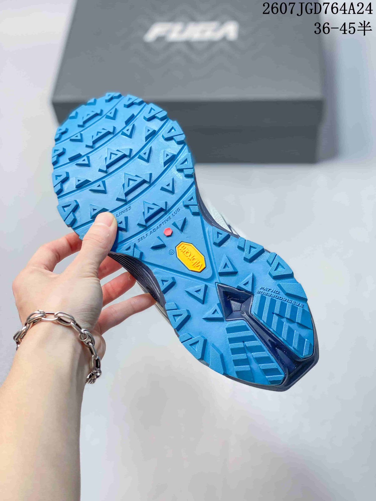 Underside view showing the blue lugged outsole, Vibram branding and geometric traction pattern.