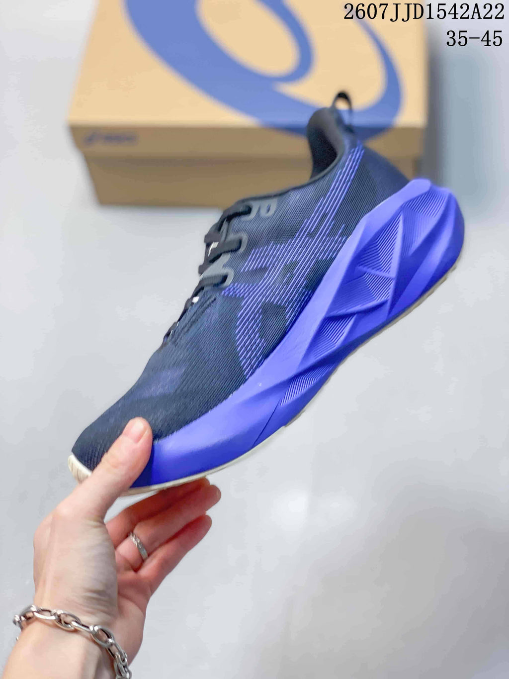 Side view showing the dark textile upper, layered side details and sculpted purple midsole.