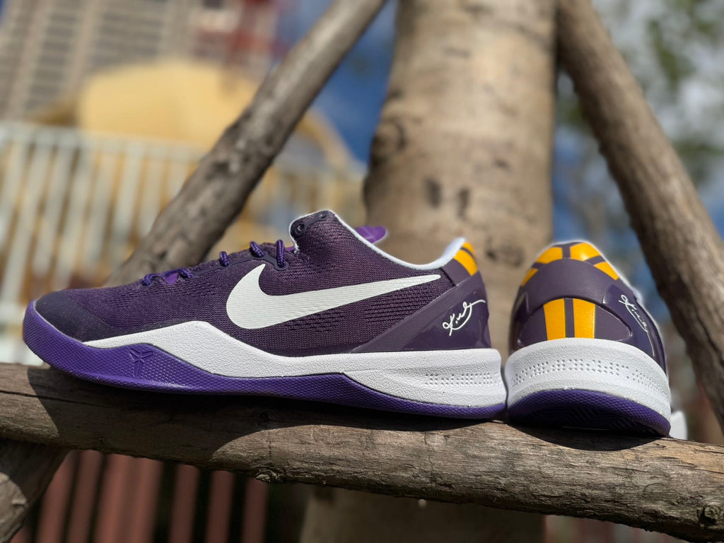 Side and heel views of a purple Kobe 8 shoe with white midsole.
