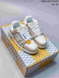 White and beige Louis Vuitton Trainer low-top sneakers shown on a patterned box