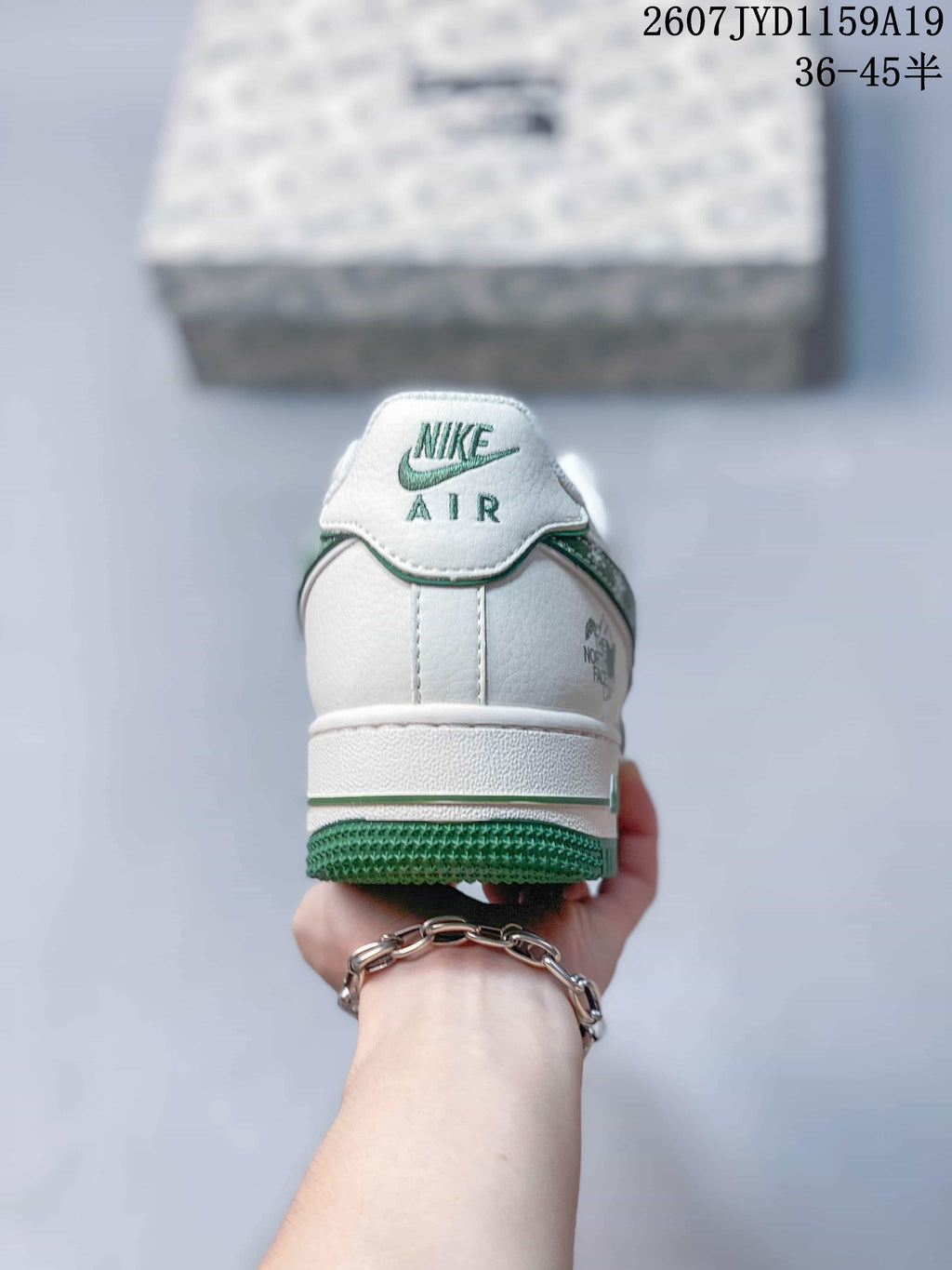Rear view of the white sneaker showing AIR branding and the green outsole edge.