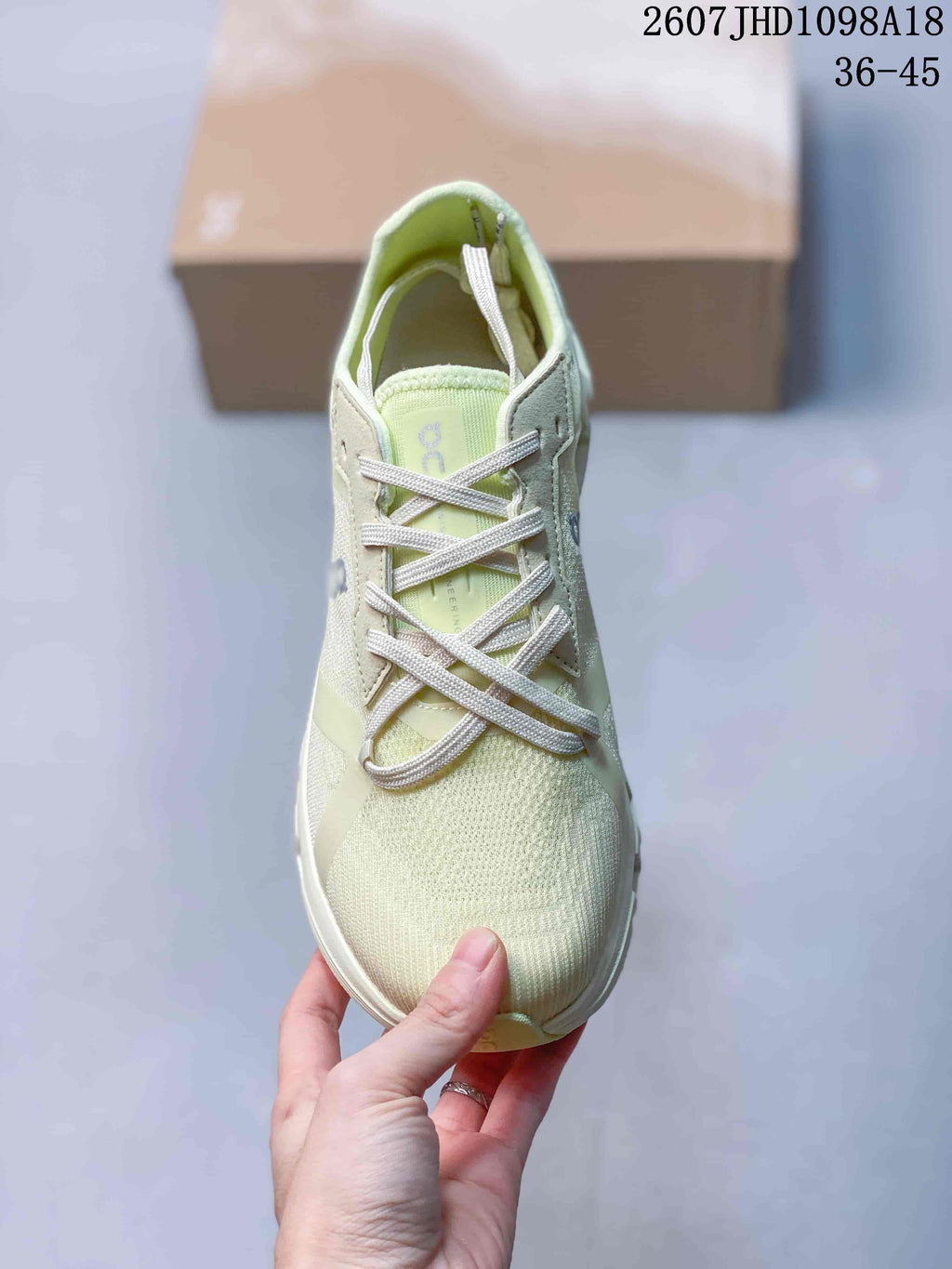 Top view of the pale green lace-up sneaker showing the textured toe box and tongue branding.