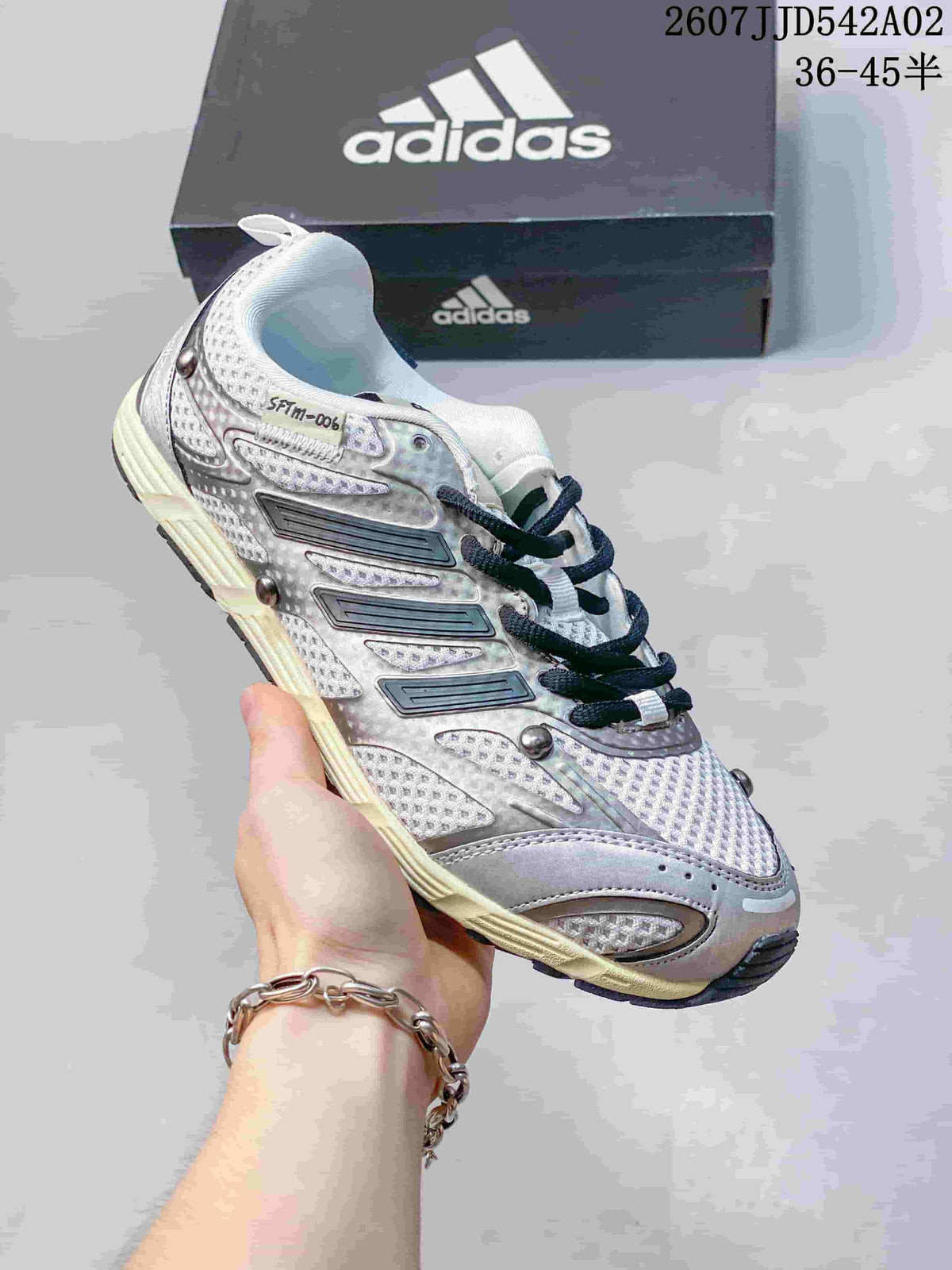 Silver-toned sneaker with dark laces, textured panels and contrast side details