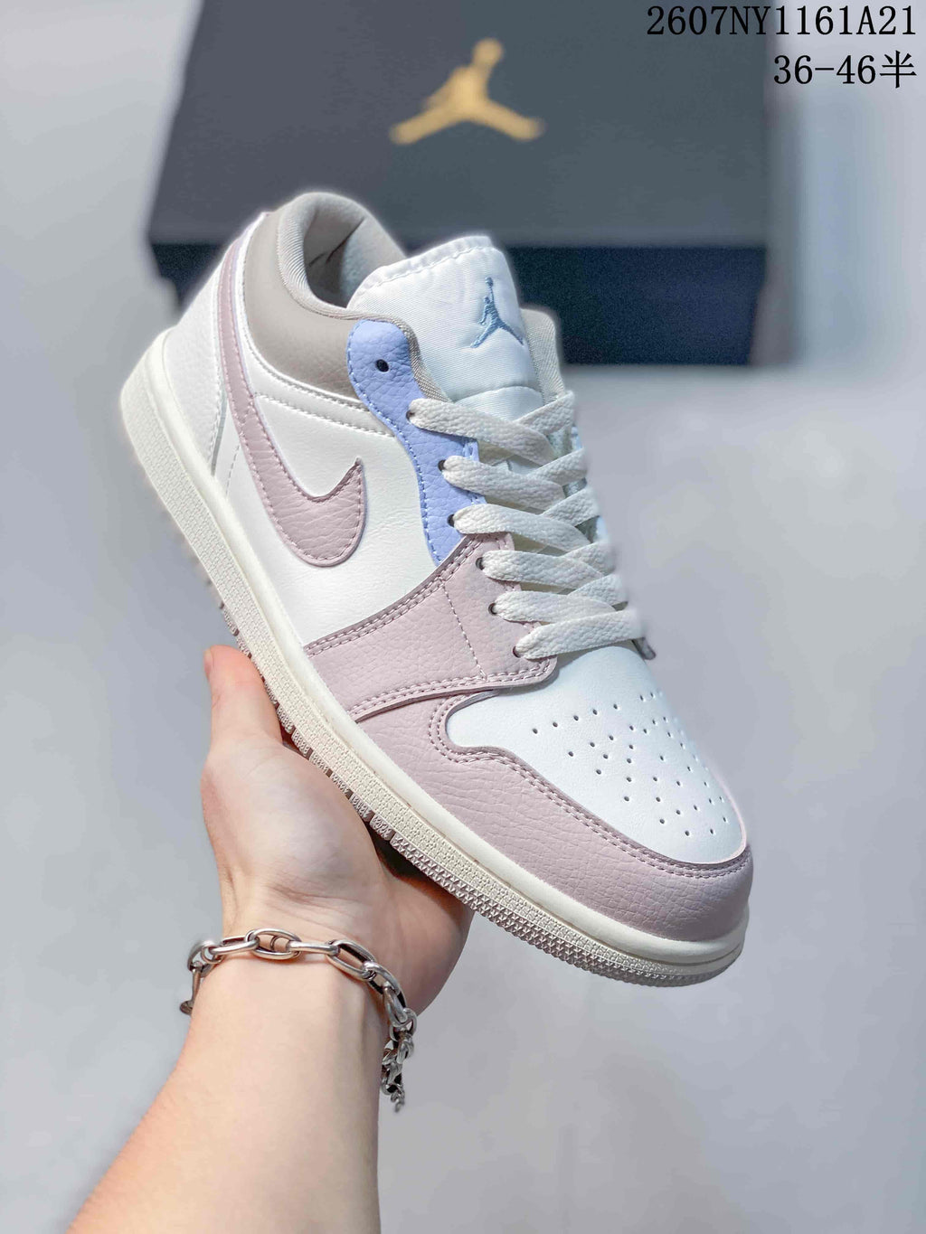 Angled side view showing the layered white and pink upper, light blue eyelet panel, padded collar and rubber outsole.