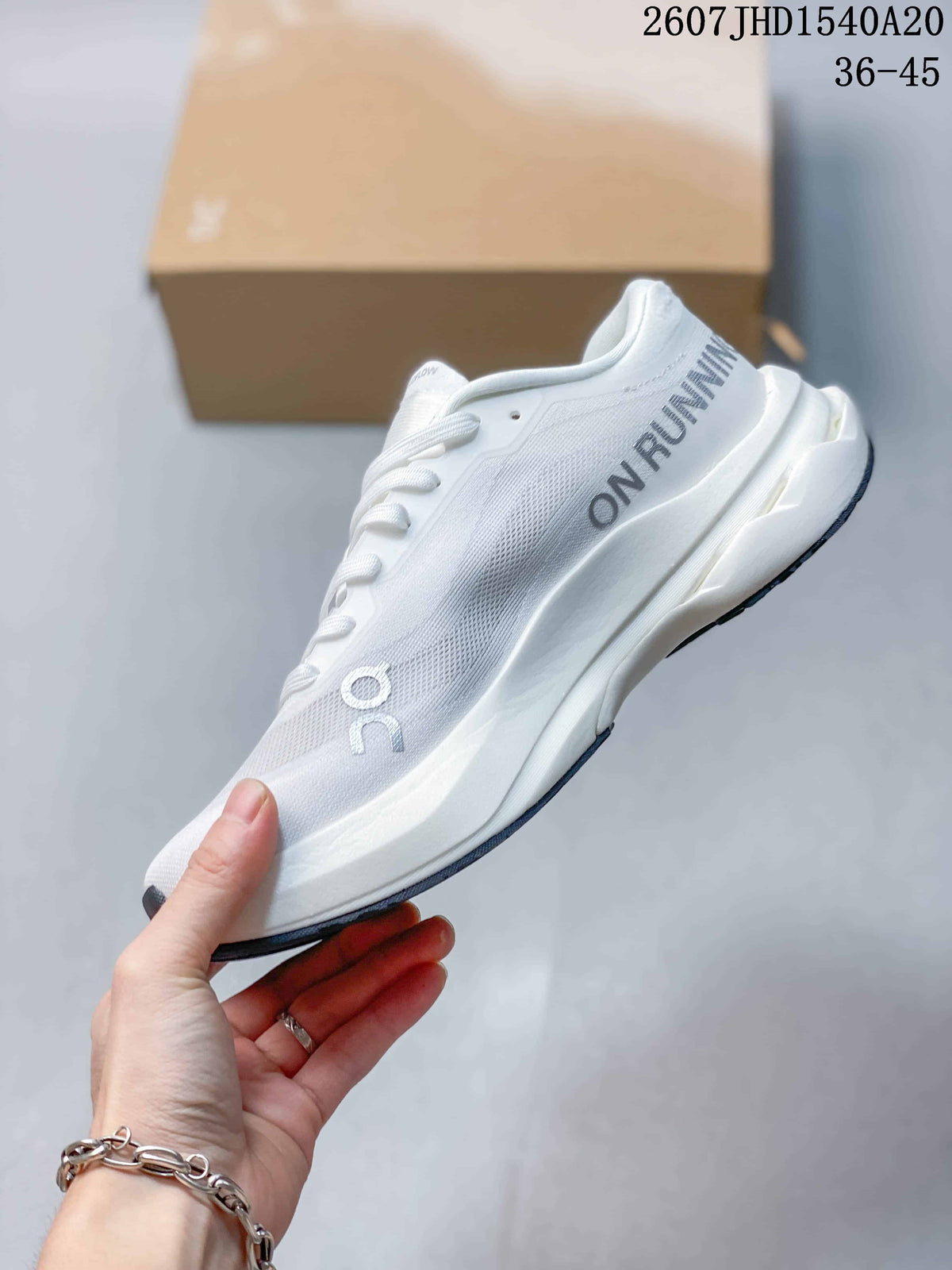 Side profile of the white sneaker showing gray side branding, a textured upper, sculpted white midsole, and dark outsole accents.