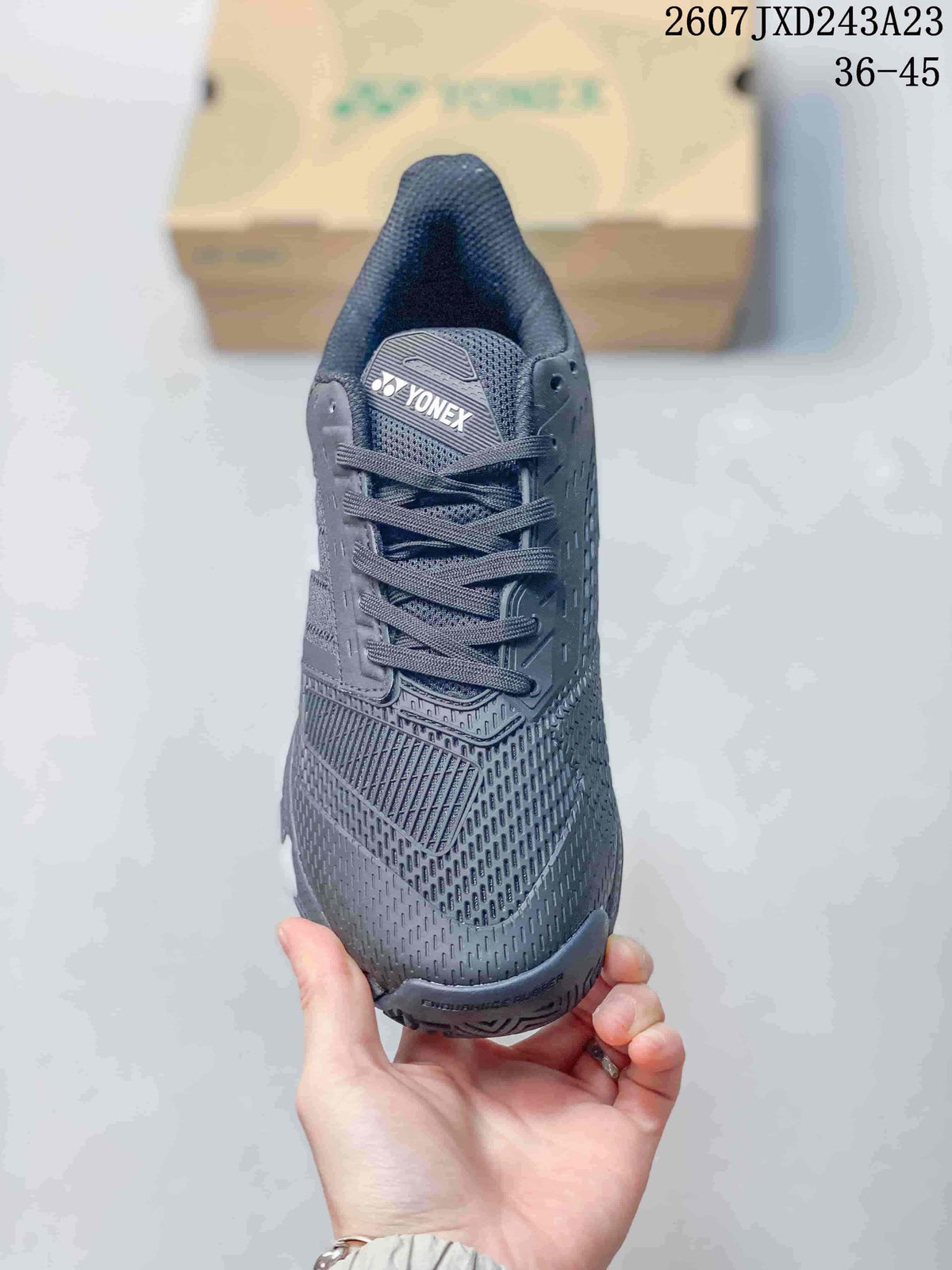 Top view of the dark lace-up Yonex tennis shoe showing the branded tongue and textured upper.