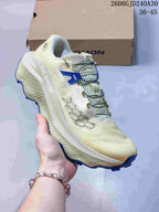 Side view of a pale yellow Salomon Ultra Glide 4 shoe with blue accents and cord lacing