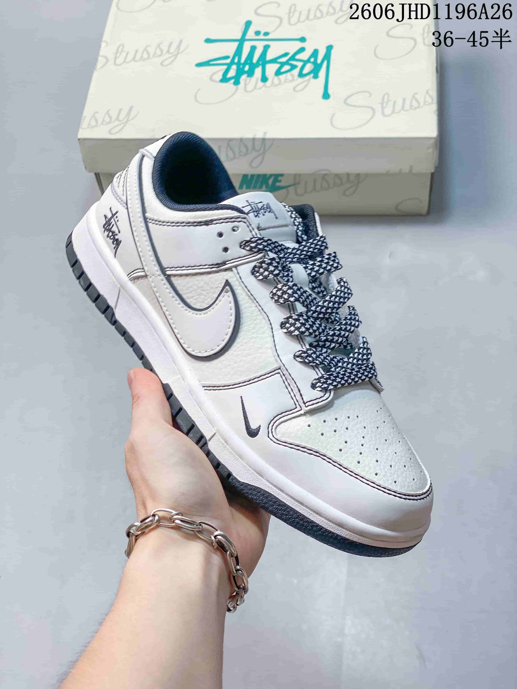 Close view of a white low-top sneaker with dark patterned laces and a small swoosh detail.