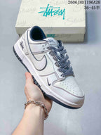 Close view of a white low-top sneaker with dark patterned laces and a small swoosh detail.