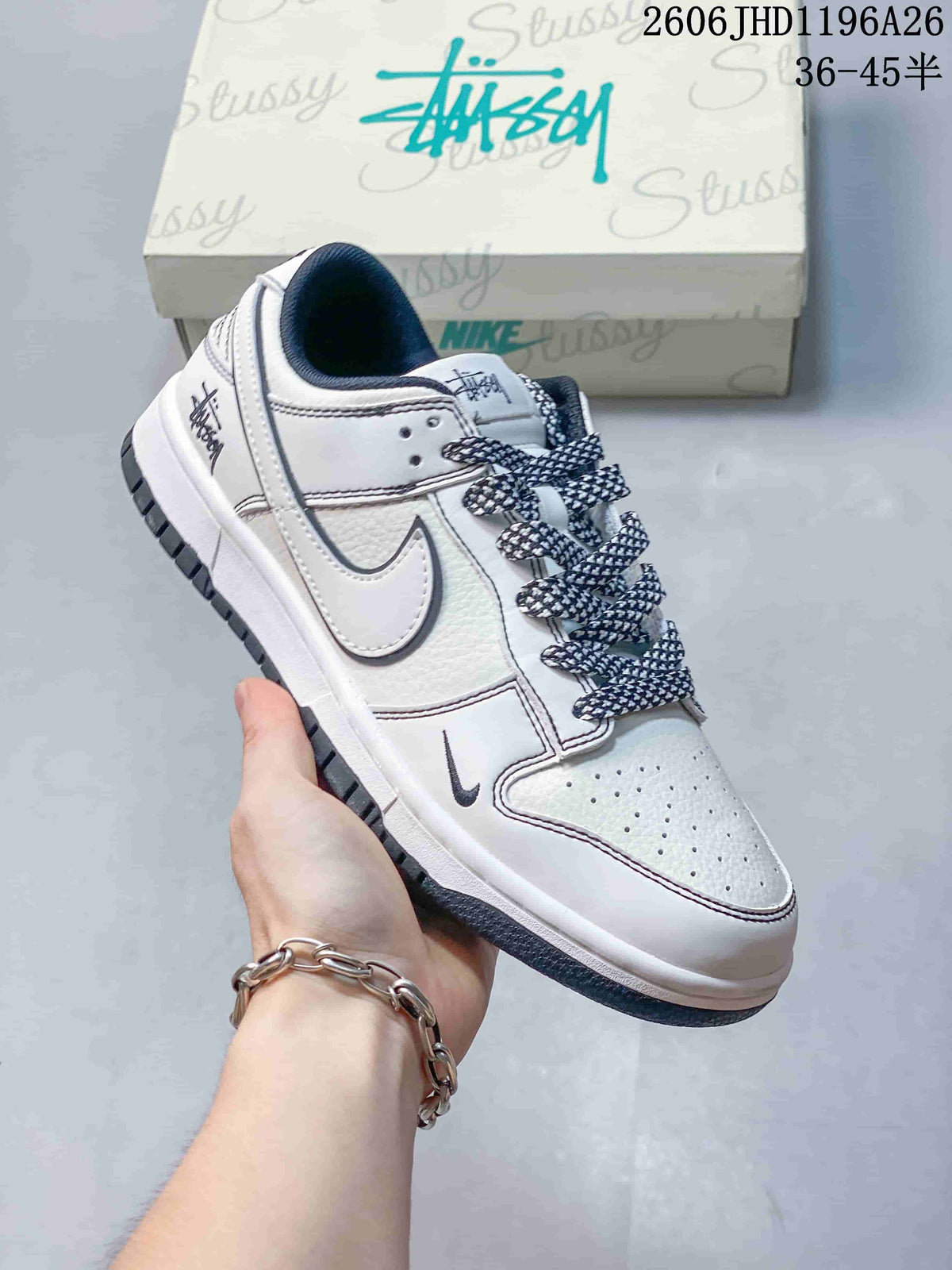 Close view of a white low-top sneaker with dark patterned laces and a small swoosh detail.