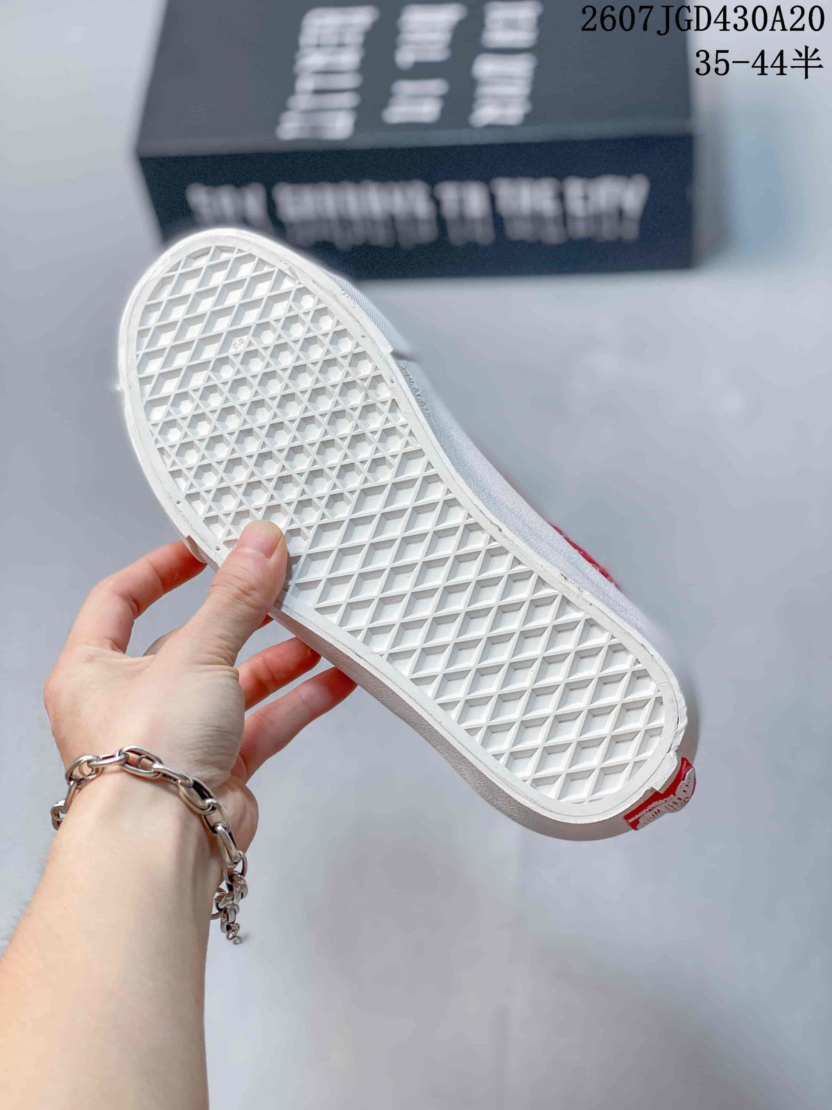Close view of the white waffle-pattern outsole on a red low-top sneaker.