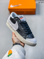 Angled close-up of the black patterned upper, oversized white Swoosh, and textured rubber sole.