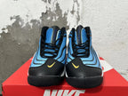 Front view of blue and black Nike sneakers with yellow Swoosh accents and lace-up closures.