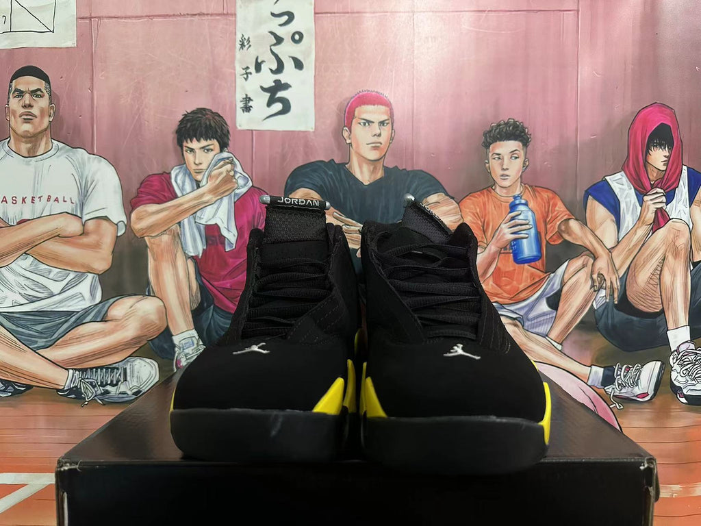 Front view of black high-top sneakers with yellow accents