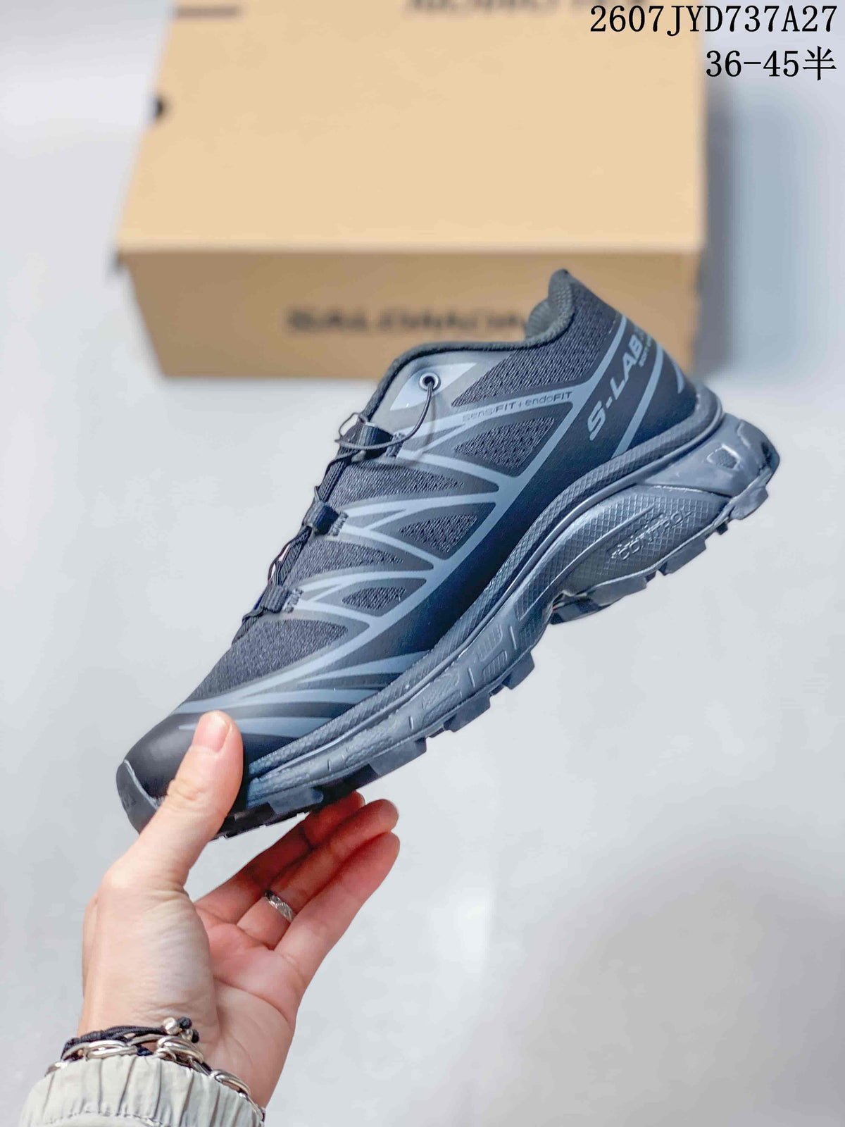 Side view of the dark gray Salomon sneaker showing layered panels, padded collar, and textured outsole.