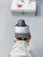 Rear view of the white sneaker showing Hello Kitty artwork, a dark heel panel, and red stitching.
