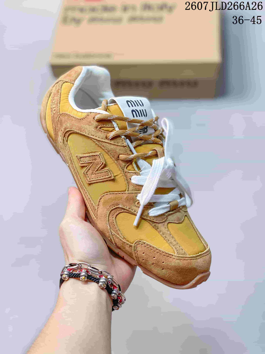 Angled view of the mustard and tan lace-up sneaker showing the rounded toe, layered upper and side logo.