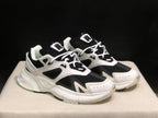 Front three-quarter view of the white and black AMIRI MA Runner pair.