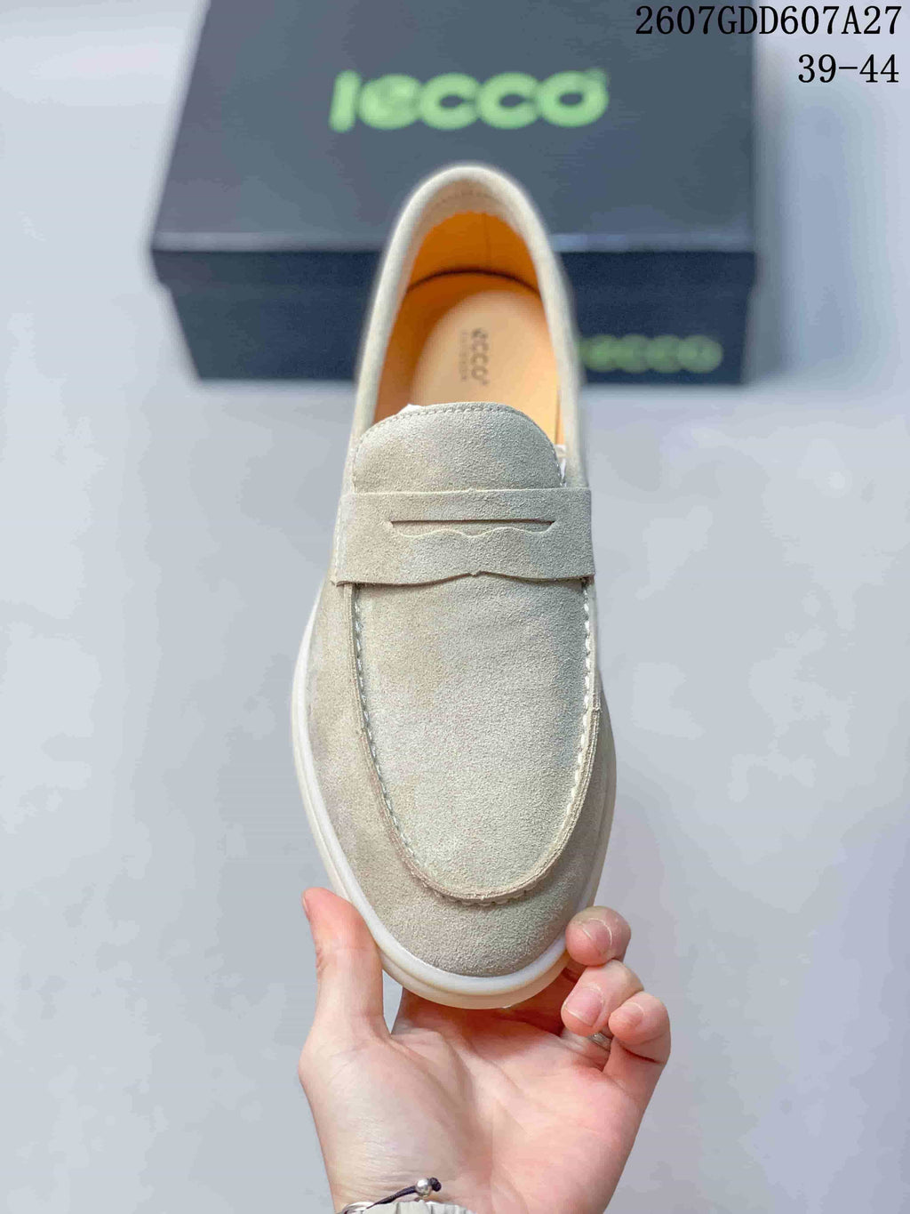 Top view of a light beige loafer showing the rounded apron toe, tonal stitching, and vamp strap.