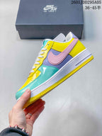 Side profile of the low-top sneaker showing the pink Swoosh, lavender side panel, yellow upper, turquoise toe area, white midsole and yellow outsole.