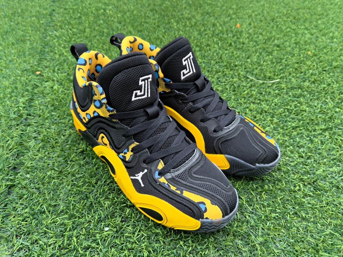 Angled view of the black and yellow leopard-print sneakers